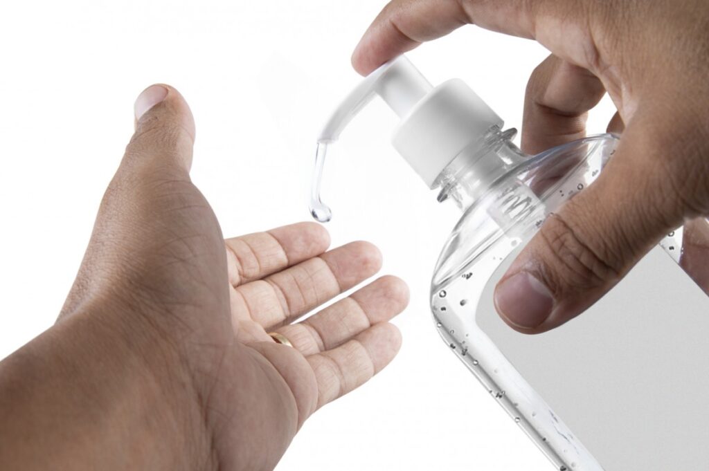 Homem limpiando las manos por alcohol gel para proteger contra el covid19